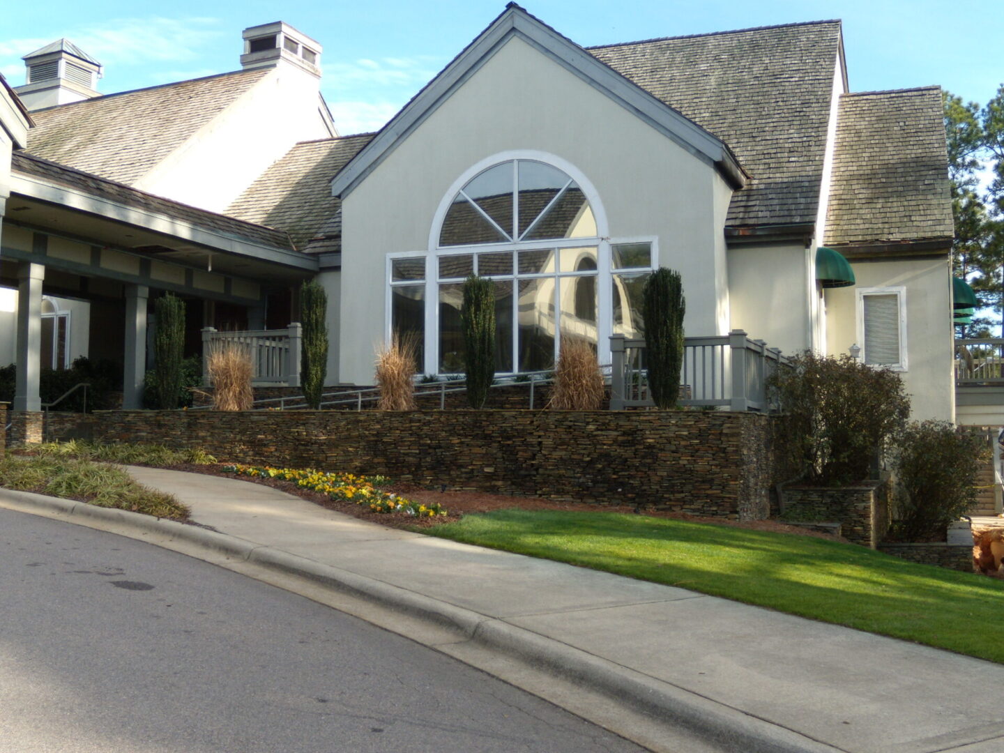 A house with a large window and green grass.