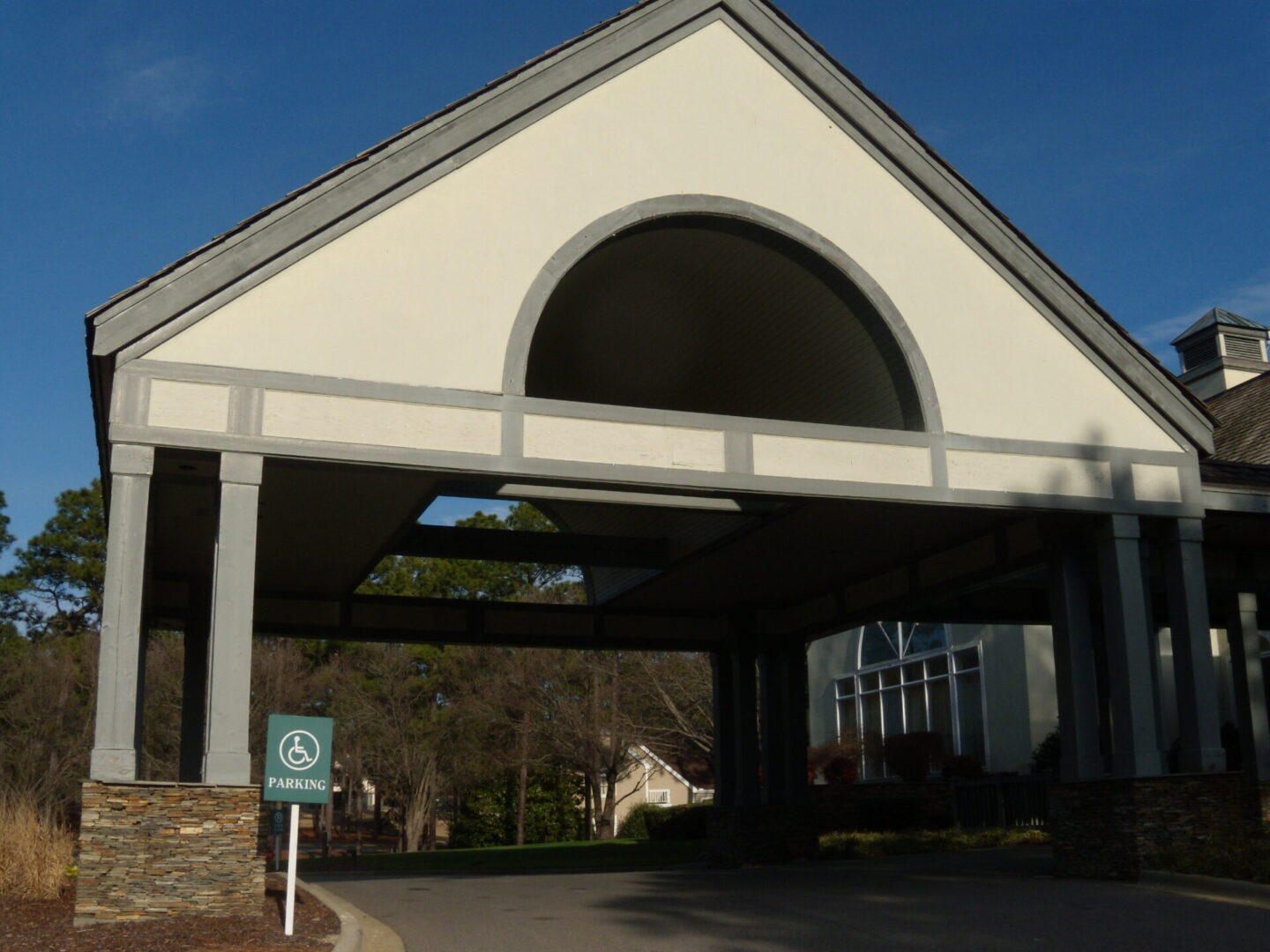 A large white building with a green sign on the side.