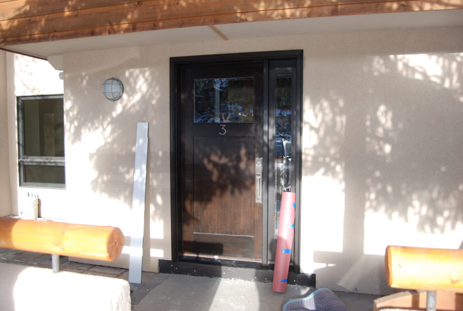 A black door with a wooden frame and glass.