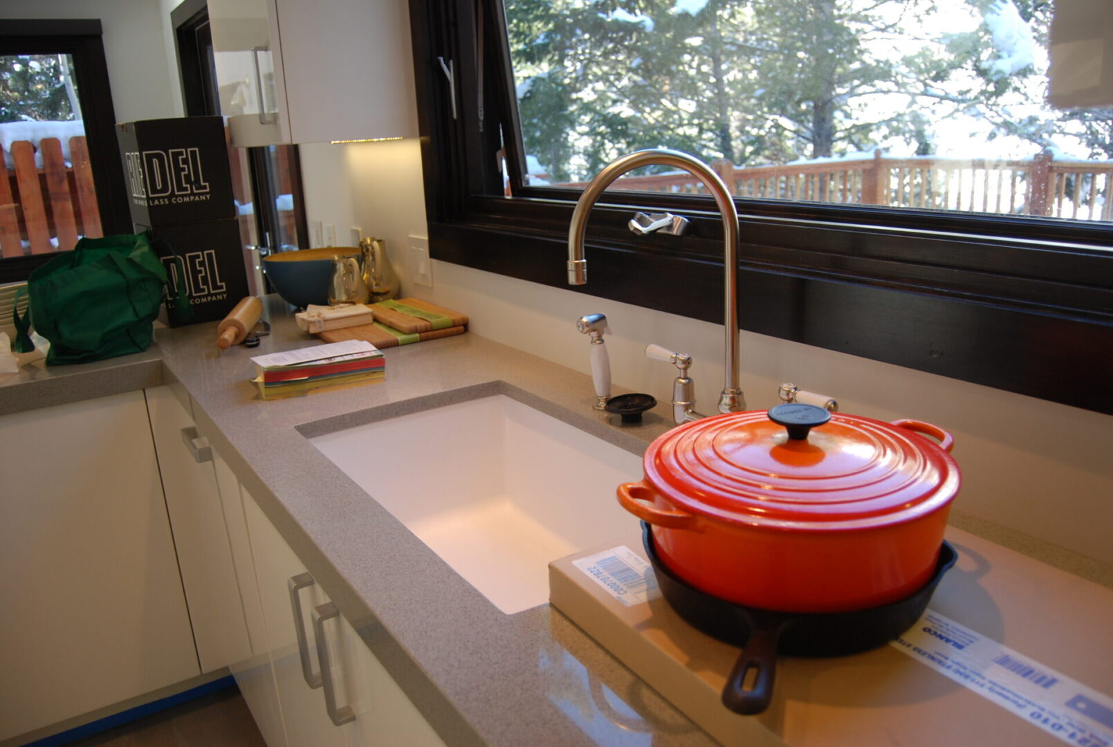 A kitchen sink with a red pot on it.