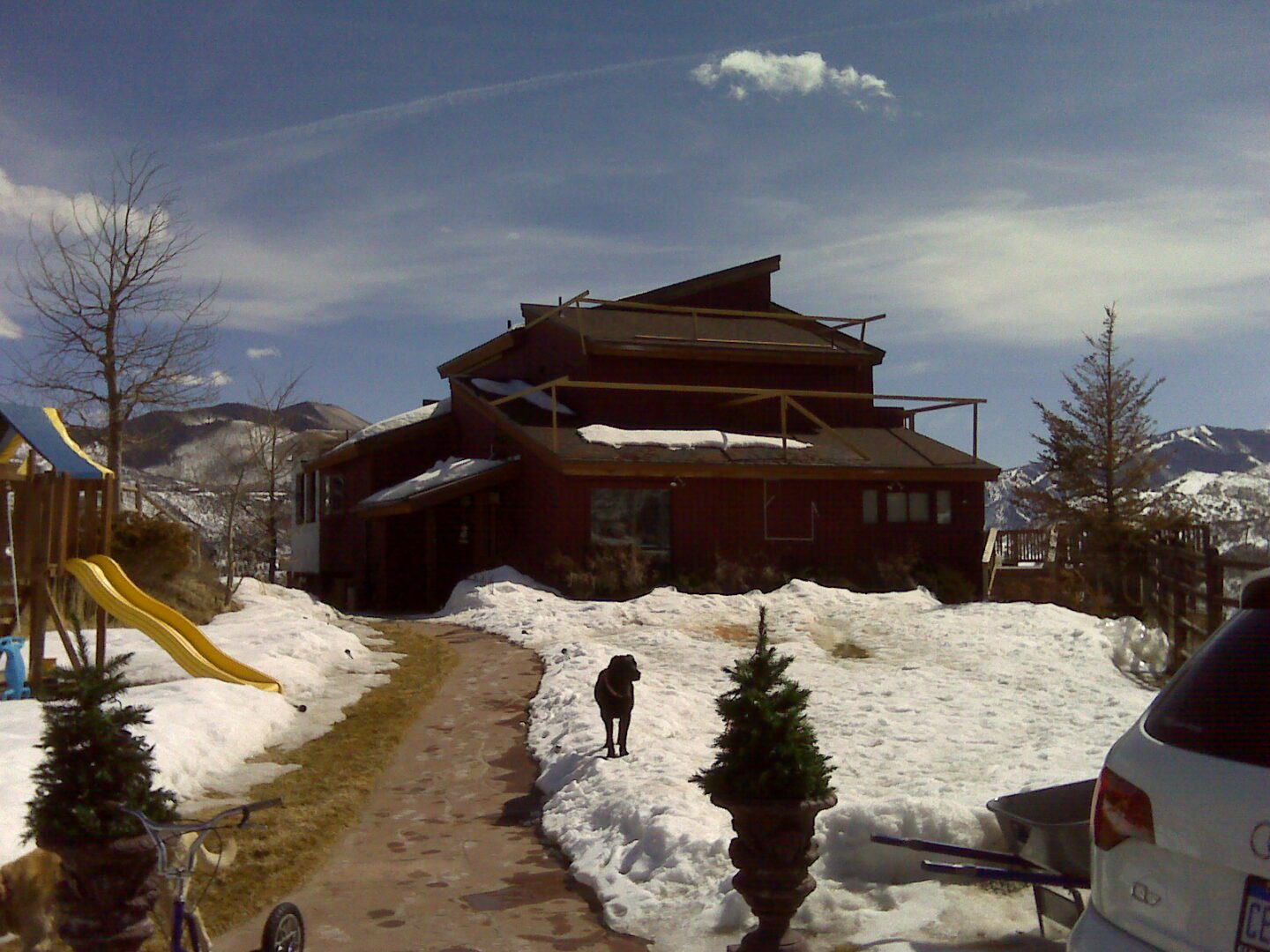 A person walking on the snow near a house.