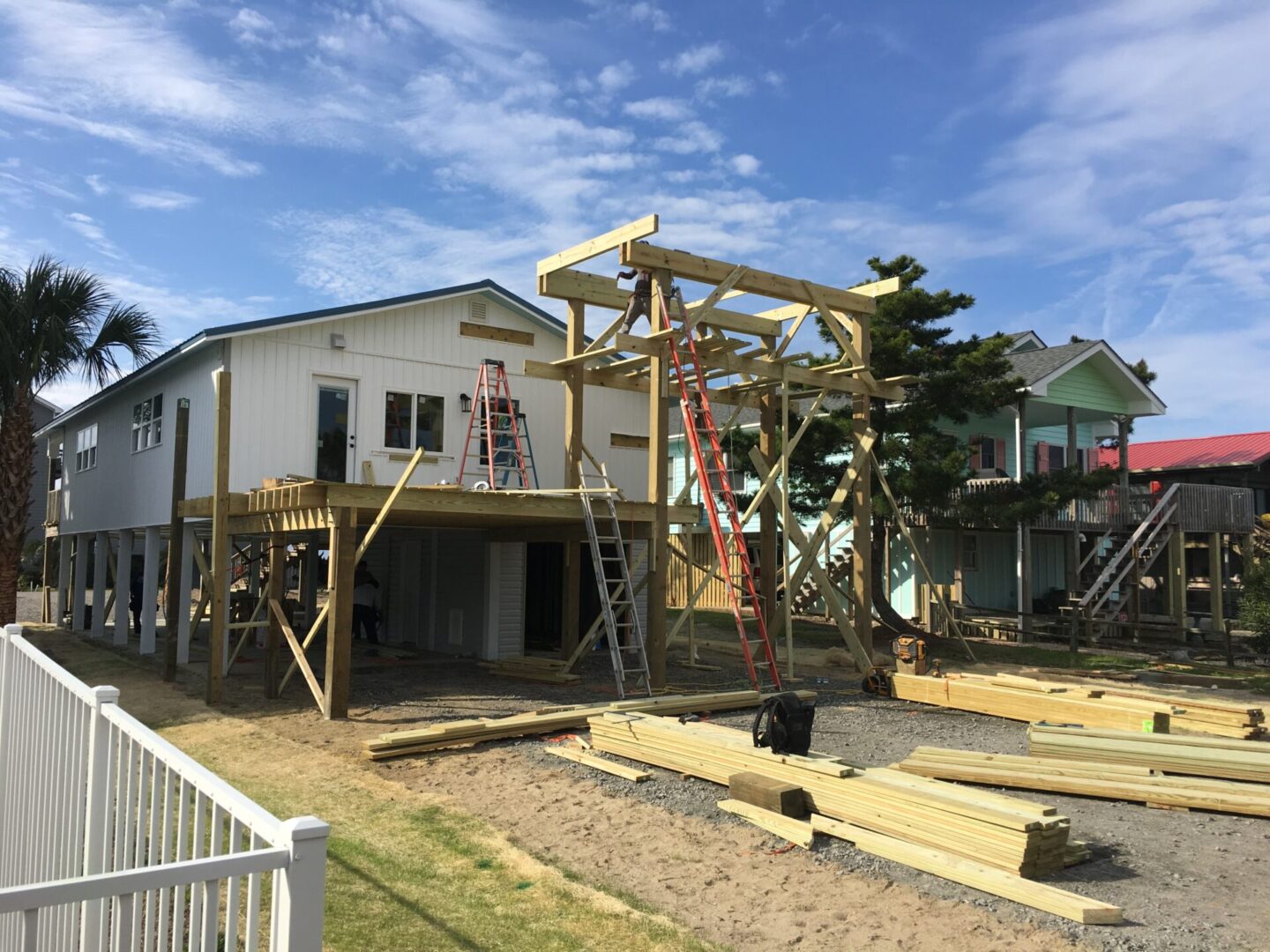 A house being built with some wood in the front yard.