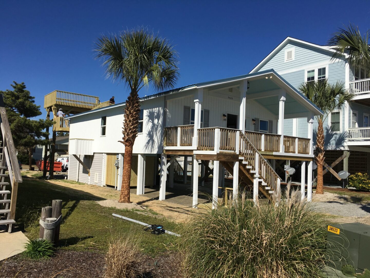 A house with palm trees and a building in the background.