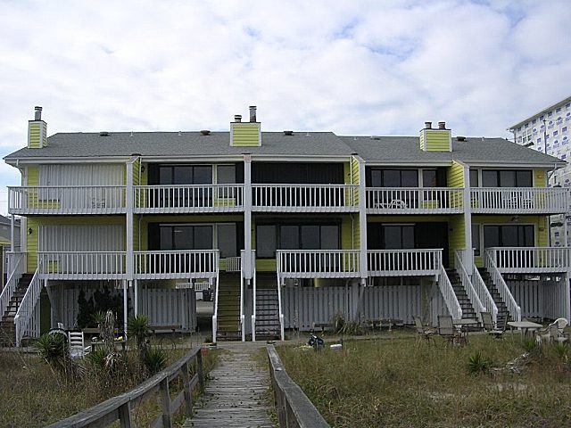 A row of yellow and white buildings on the beach.