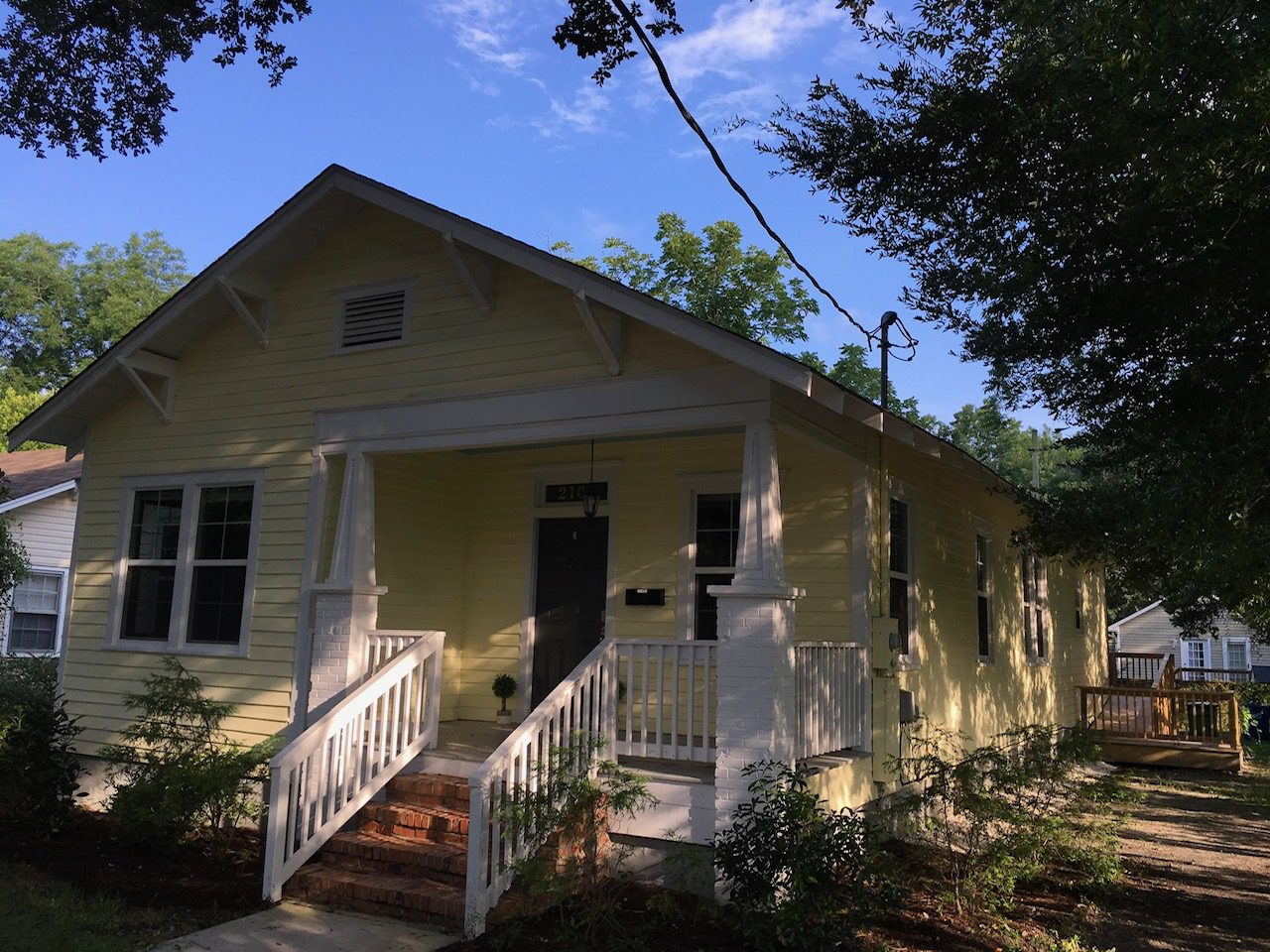 A yellow house with white steps leading to the front door.