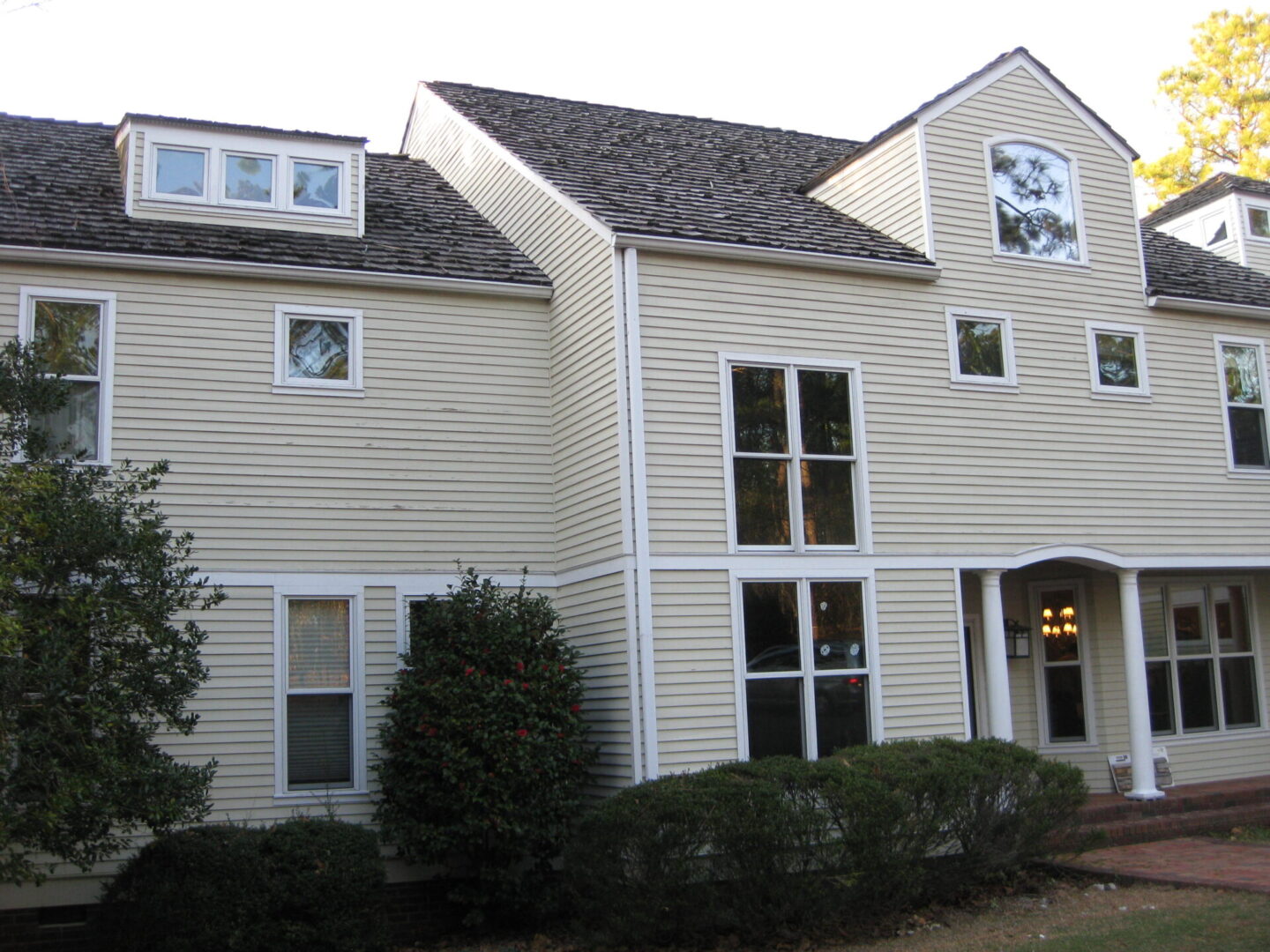 A large white house with a clock on the side of it.