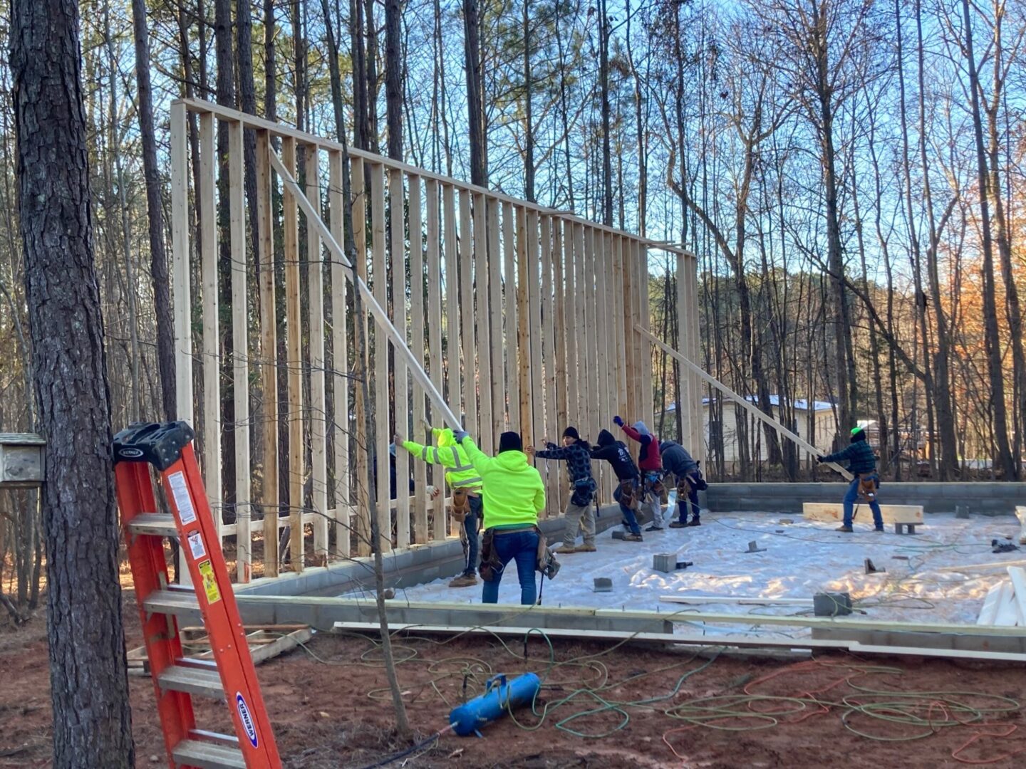 A group of people standing around building construction.