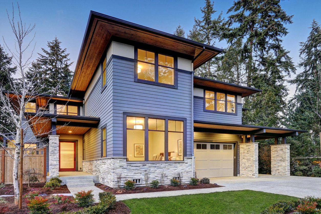 A blue house with a stone wall and garage.